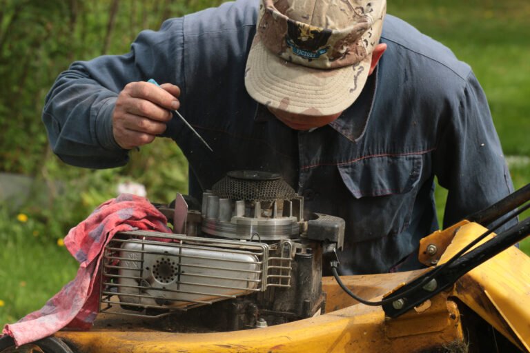 Mann repariert den Motor eines Rasenmähers